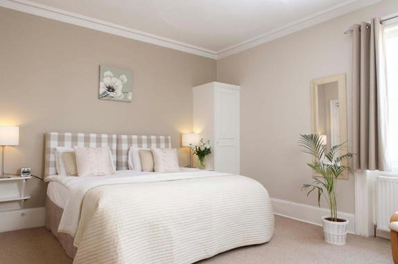 Light-filled period living room freshly painted in warm off-white with a deep blue-green accent wall